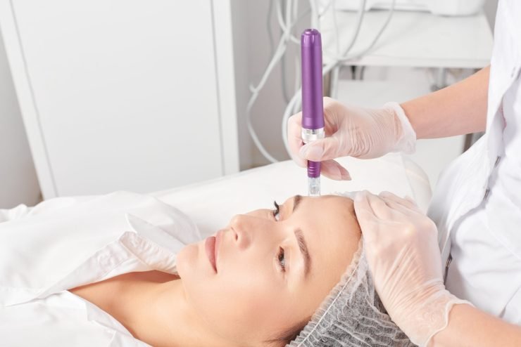 Beautician makes mesotherapy injection for rejuvenation woman face, anti aging non surgical cosmetic procedure in beauty salon. Cosmetologist hands in gloves makes facial micro needle injections